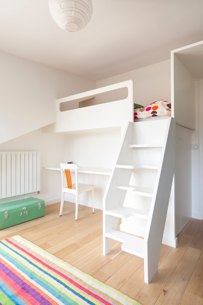 Idée de décoration pour une chambre neutre de 4 à 10 ans design de taille moyenne avec un bureau, un mur blanc et parquet clair.