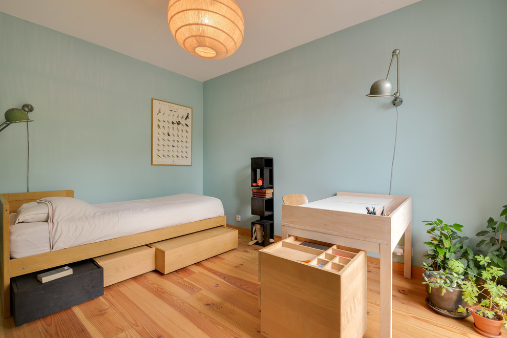 Immagine di una cameretta per bambini nordica di medie dimensioni con pareti blu, parquet chiaro e pavimento marrone