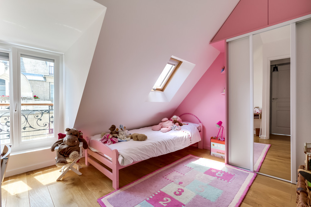 Diseño de dormitorio infantil de 4 a 10 años clásico renovado de tamaño medio con paredes blancas y suelo de madera clara
