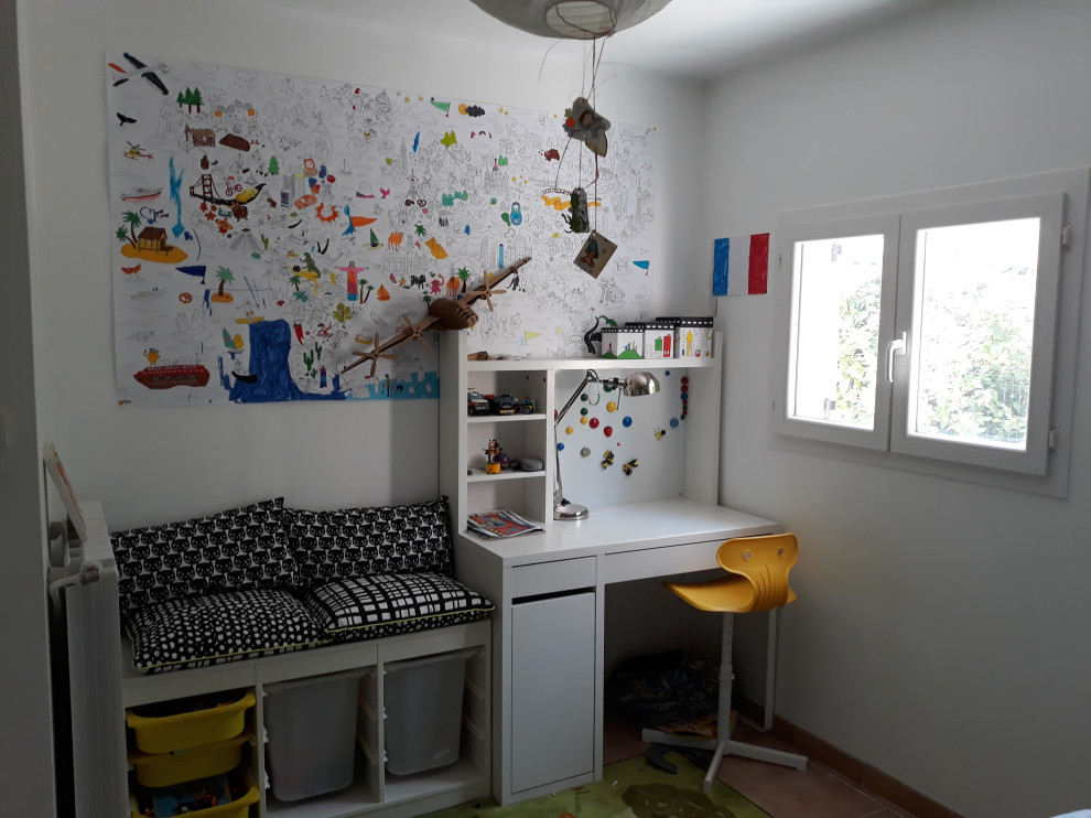 Idée de décoration pour une chambre d'enfant de 4 à 10 ans design de taille moyenne avec un mur blanc, tomettes au sol et un sol marron.