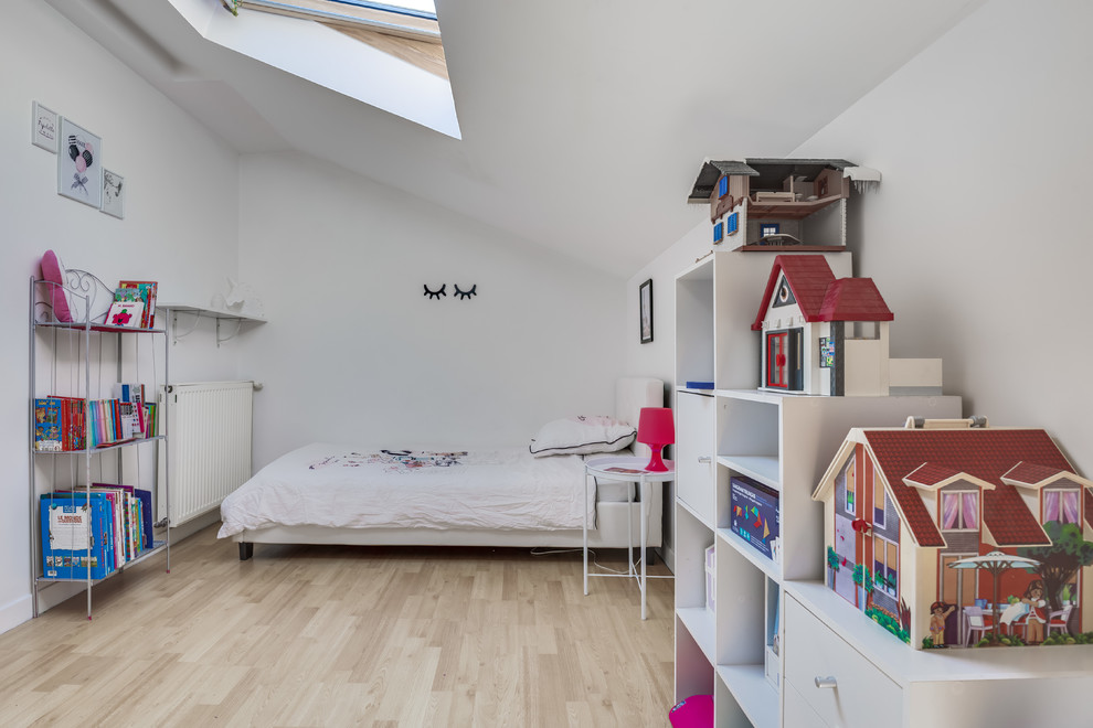 Cette photo montre une chambre d'enfant de 4 à 10 ans tendance avec un mur blanc et sol en stratifié.