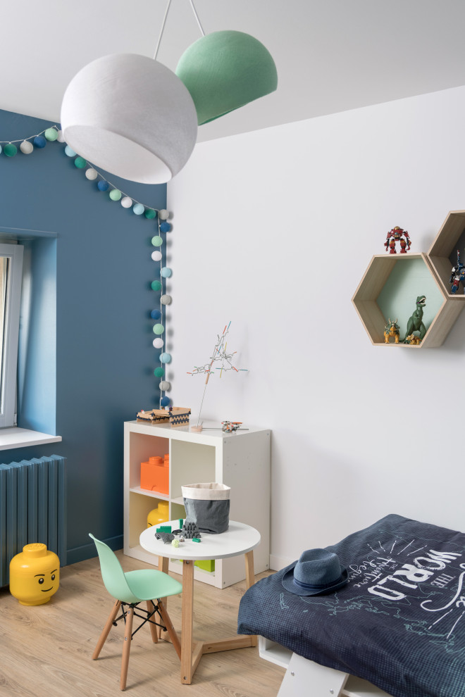 Idée de décoration pour une chambre de garçon de 4 à 10 ans design de taille moyenne avec parquet clair, un sol beige et un mur blanc.