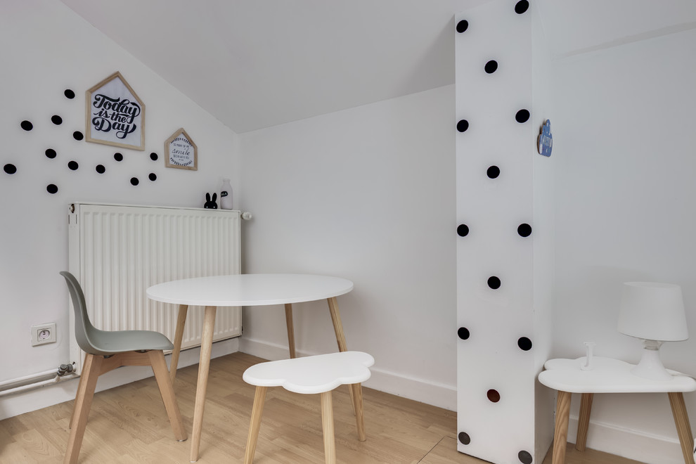 Immagine di una cameretta per bambini da 1 a 3 anni minimal con pareti bianche e pavimento in laminato