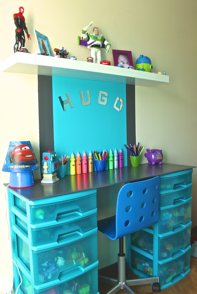 Immagine di una piccola cameretta per bambini da 4 a 10 anni minimalista con pavimento in legno massello medio e pareti verdi