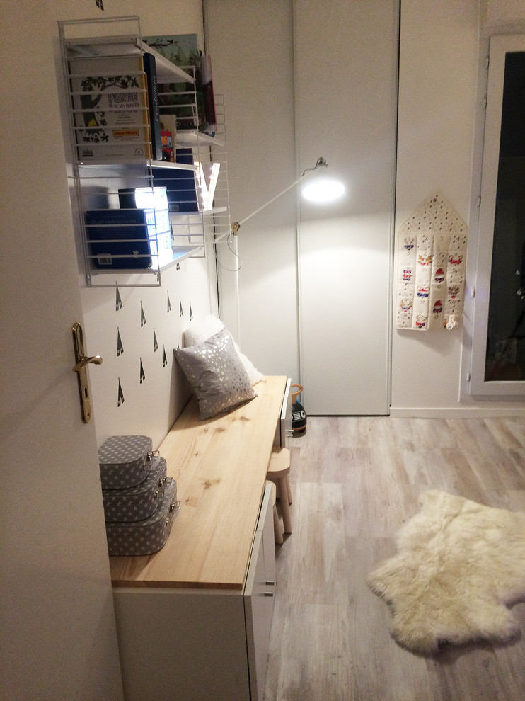 Cette photo montre une petite chambre d'enfant de 4 à 10 ans scandinave avec un mur blanc et parquet clair.