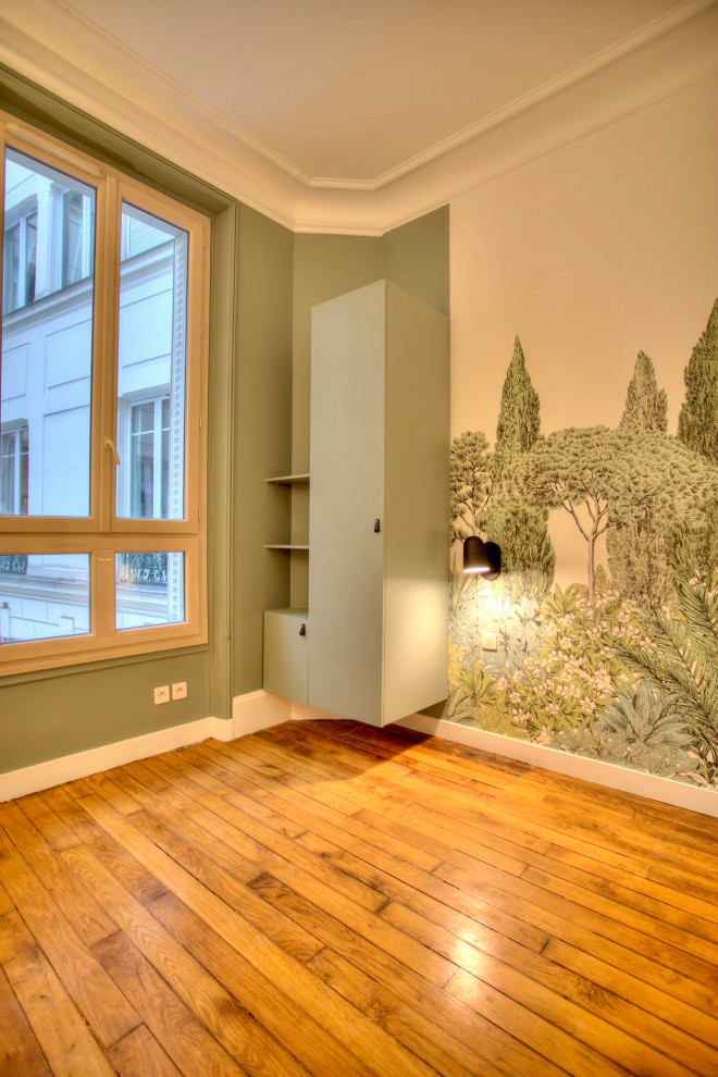 Foto de dormitorio infantil de 4 a 10 años de tamaño medio con paredes verdes, suelo de madera clara y papel pintado