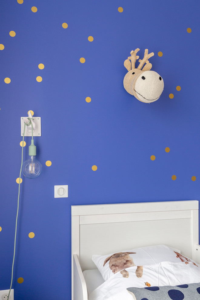 Cette photo montre une chambre d'enfant de 1 à 3 ans tendance de taille moyenne avec un mur blanc et parquet clair.