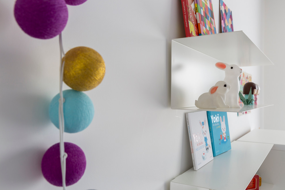 Inspiration pour une chambre de fille de 1 à 3 ans design de taille moyenne avec un bureau, un mur blanc et parquet clair.