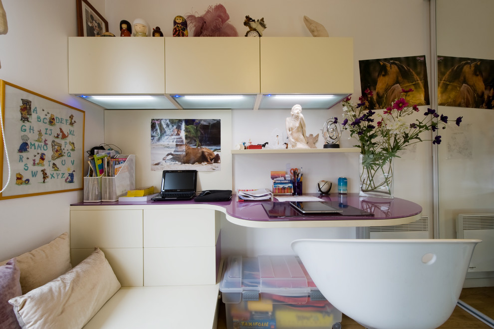 Exempel på ett stort modernt barnrum kombinerat med skrivbord, med vita väggar och ljust trägolv