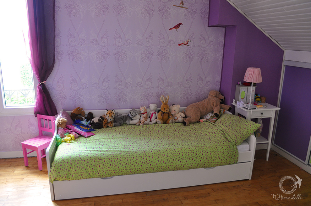 Esempio di una grande cameretta per bambini da 4 a 10 anni con pareti viola e parquet chiaro