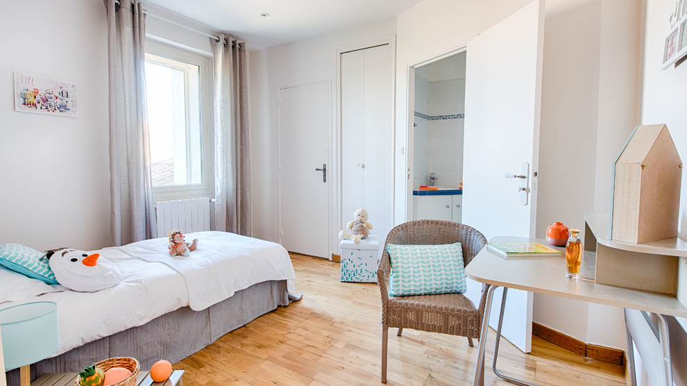 Nordisches Kinderzimmer mit Schlafplatz, weißer Wandfarbe, hellem Holzboden und beigem Boden in Grenoble