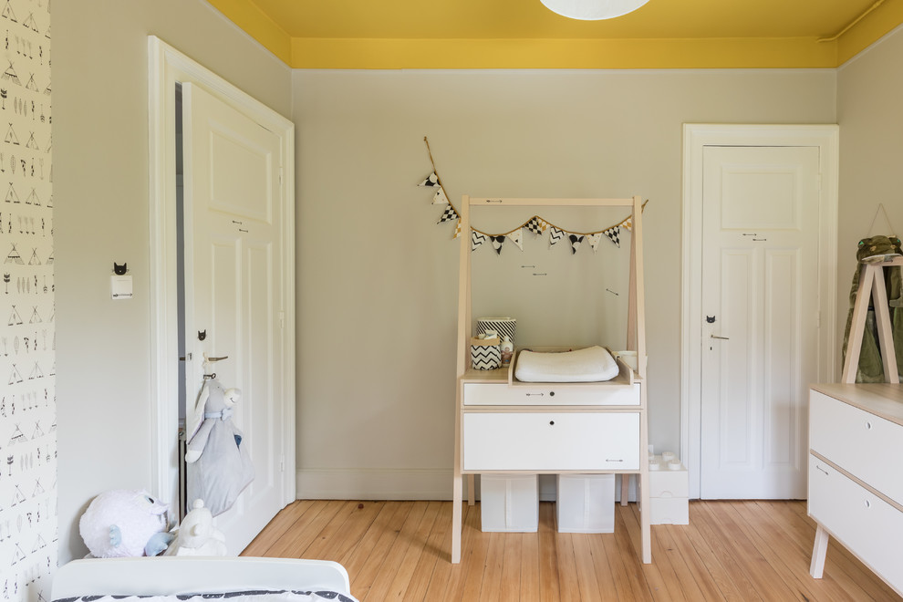 Idéer för mellanstora funkis könsneutrala småbarnsrum kombinerat med sovrum, med grå väggar, ljust trägolv och beiget golv