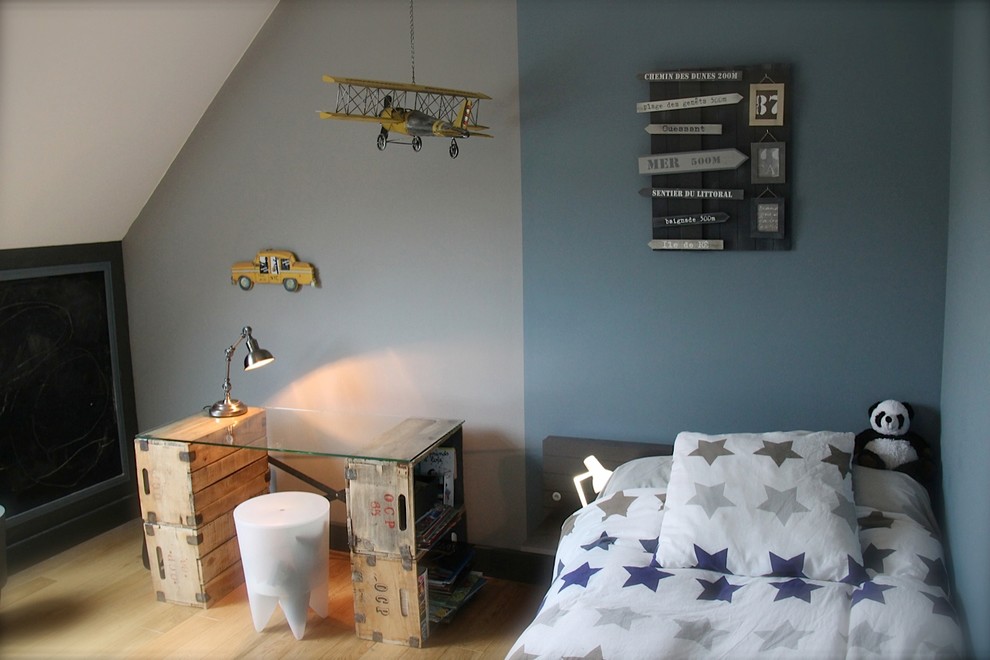 Réalisation d'une chambre de garçon de 4 à 10 ans bohème de taille moyenne avec un bureau, un mur bleu, parquet clair et un sol beige.