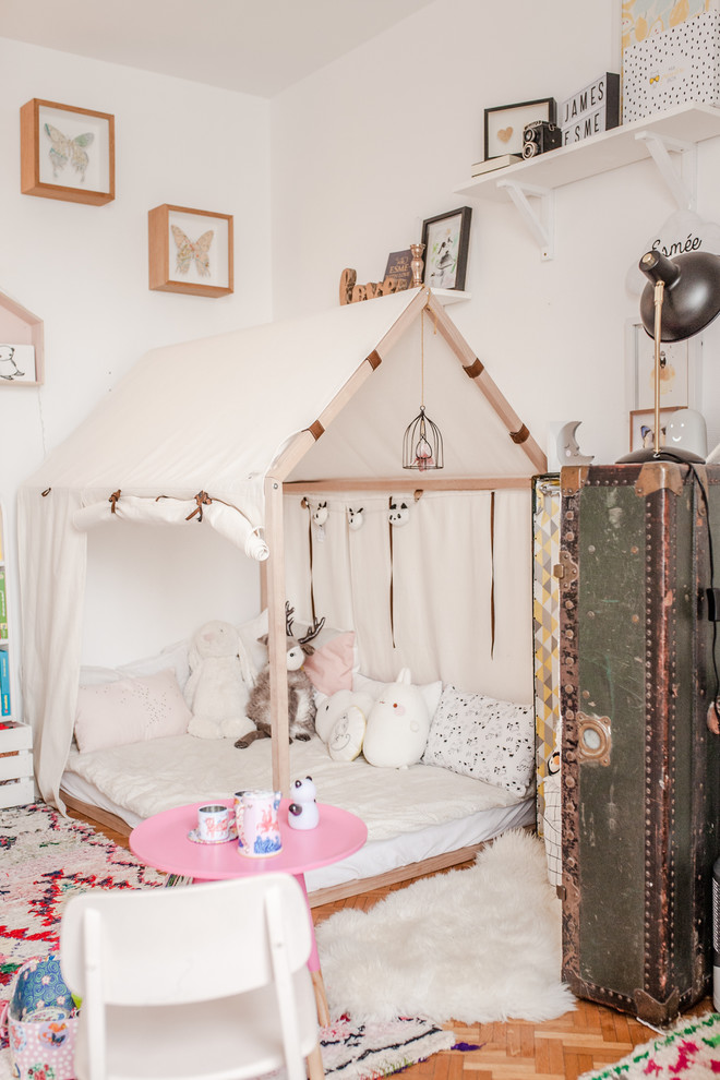 Cette image montre une chambre d'enfant bohème avec un mur blanc, parquet clair et un sol marron.