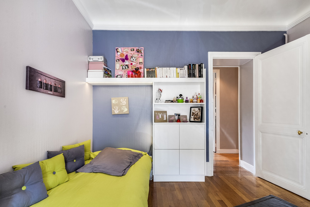 Idée de décoration pour une chambre d'enfant design de taille moyenne avec un mur bleu, parquet clair et un sol marron.