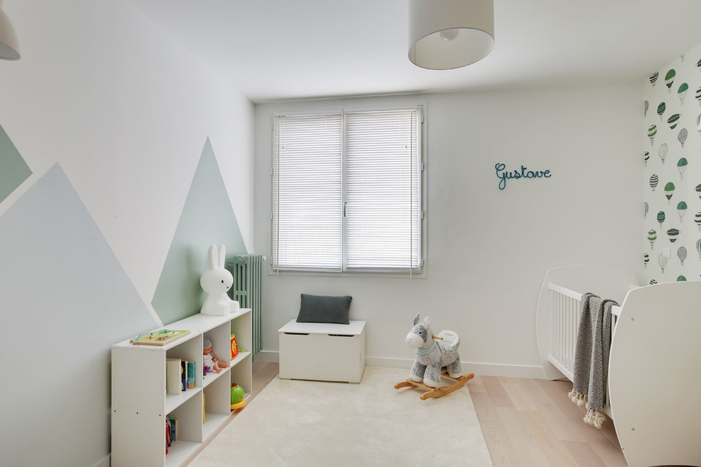 Cette photo montre une chambre d'enfant de 1 à 3 ans scandinave de taille moyenne avec un mur gris et parquet clair.