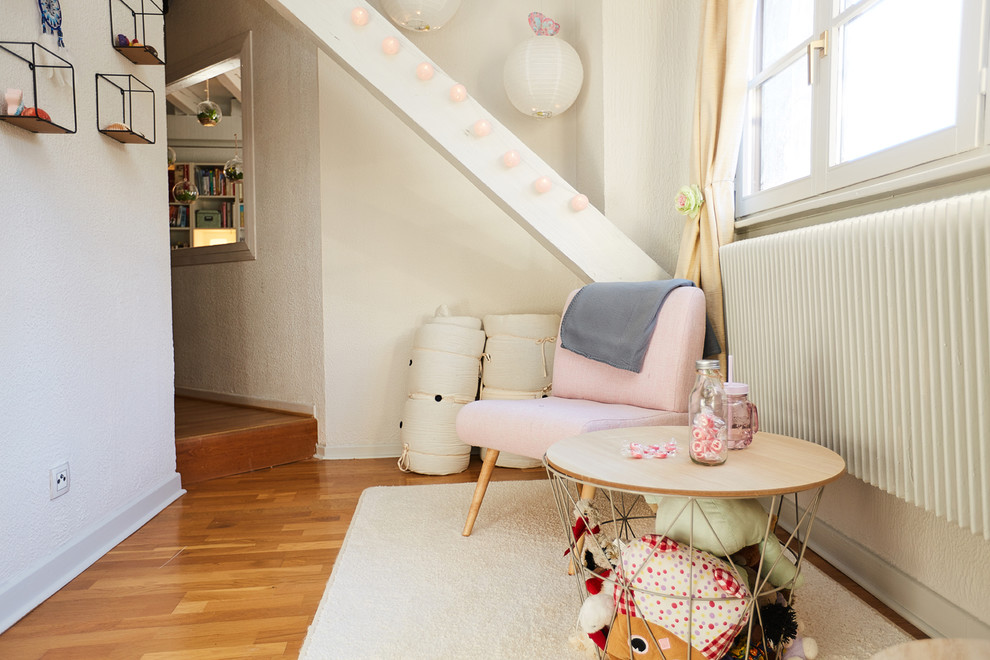 Geräumiges Shabby-Chic Kinderzimmer mit Spielecke, weißer Wandfarbe, hellem Holzboden und beigem Boden in Sonstige