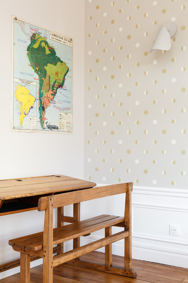 Réalisation d'une chambre neutre de 4 à 10 ans minimaliste de taille moyenne avec un bureau, un mur beige, un sol en bois brun et un sol marron.