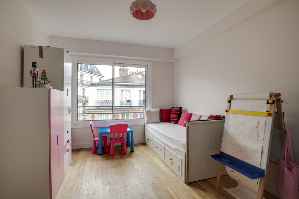 Exemple d'une chambre d'enfant de 4 à 10 ans tendance de taille moyenne avec un mur rose et parquet clair.