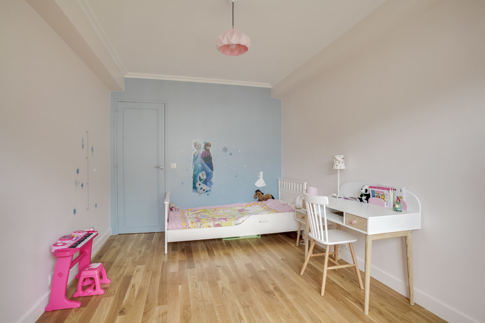 Idée de décoration pour une chambre d'enfant de 4 à 10 ans design de taille moyenne avec un mur rose et parquet clair.