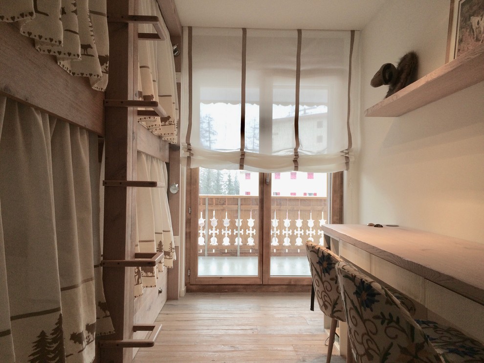 Modelo de dormitorio infantil rústico pequeño con paredes beige y suelo de madera clara