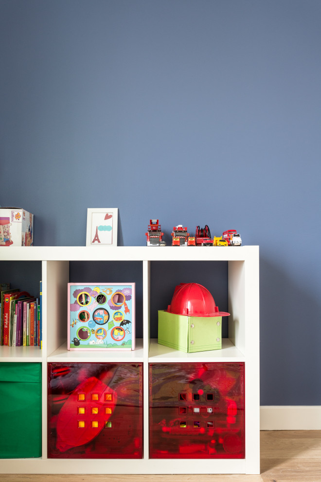 Foto di una cameretta per bambini minimalista di medie dimensioni con pareti blu, parquet chiaro e pavimento beige