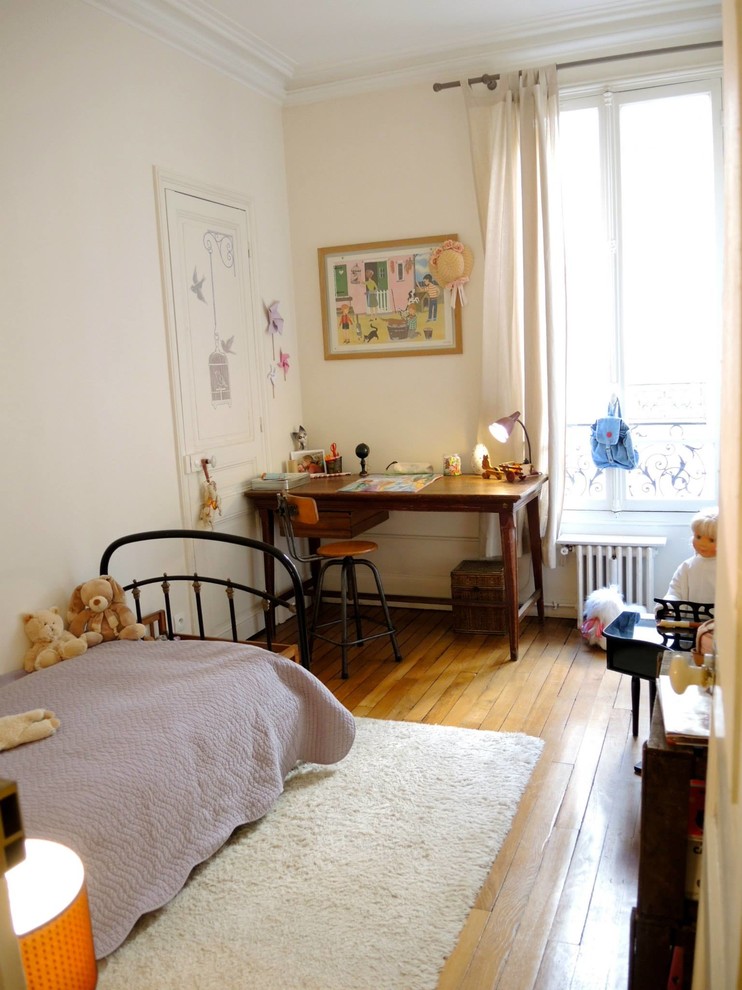 Exemple d'une petite chambre de fille de 4 à 10 ans éclectique avec un bureau, un mur blanc et un sol en bois brun.