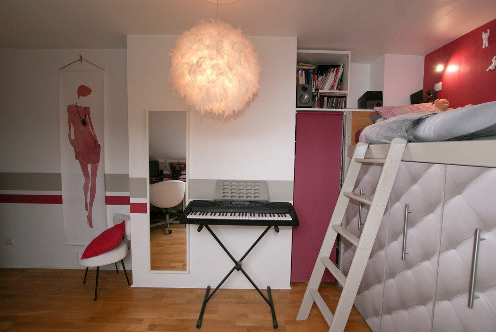 Mittelgroßes Modernes Kinderzimmer mit Schlafplatz, rosa Wandfarbe und hellem Holzboden in Paris