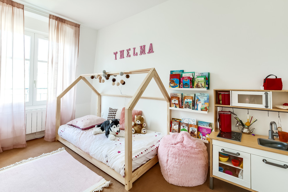 Medium sized modern children’s room for girls in Paris with white walls.