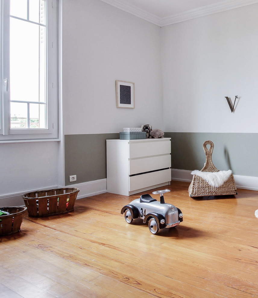 Immagine di una cameretta per bambini da 4 a 10 anni design di medie dimensioni con pareti bianche, parquet chiaro e pavimento beige
