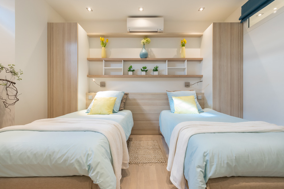 Immagine di una cameretta per bambini stile marino con pareti bianche, parquet chiaro e pavimento beige