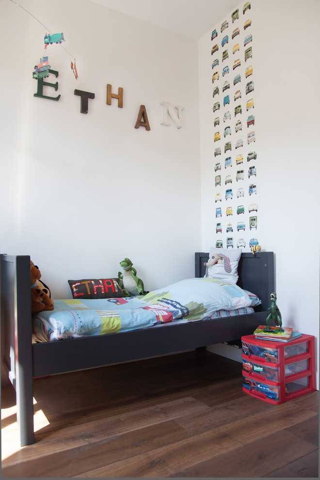 Idéer för ett stort eklektiskt barnrum kombinerat med sovrum, med vita väggar och mellanmörkt trägolv