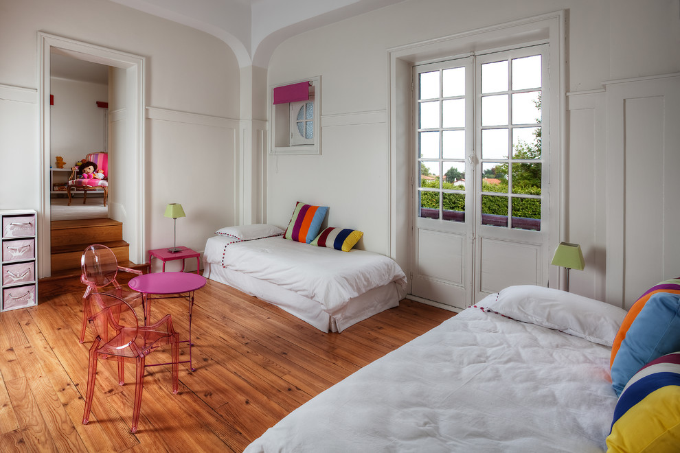 Foto på ett eklektiskt flickrum kombinerat med sovrum och för 4-10-åringar, med vita väggar och mellanmörkt trägolv