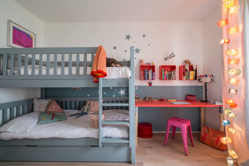 Cette image montre une chambre de fille de 4 à 10 ans design de taille moyenne avec un bureau, parquet clair, un mur multicolore et un lit superposé.