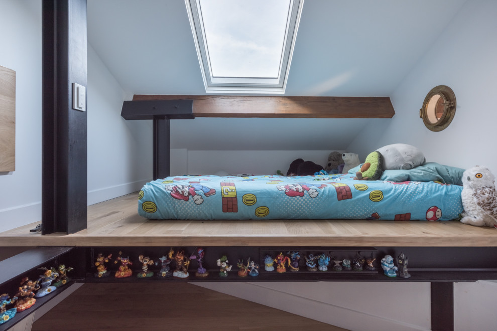 Immagine di una piccola cameretta per bambini da 4 a 10 anni contemporanea con pareti bianche e parquet chiaro