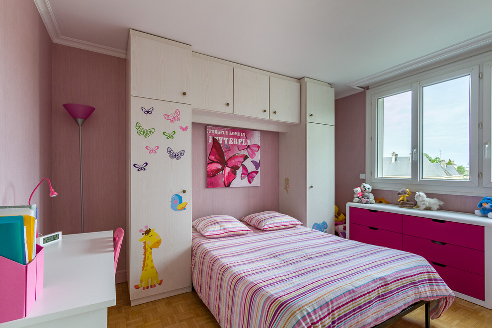Esempio di una cameretta per bambini da 4 a 10 anni minimal con pareti rosa e parquet chiaro