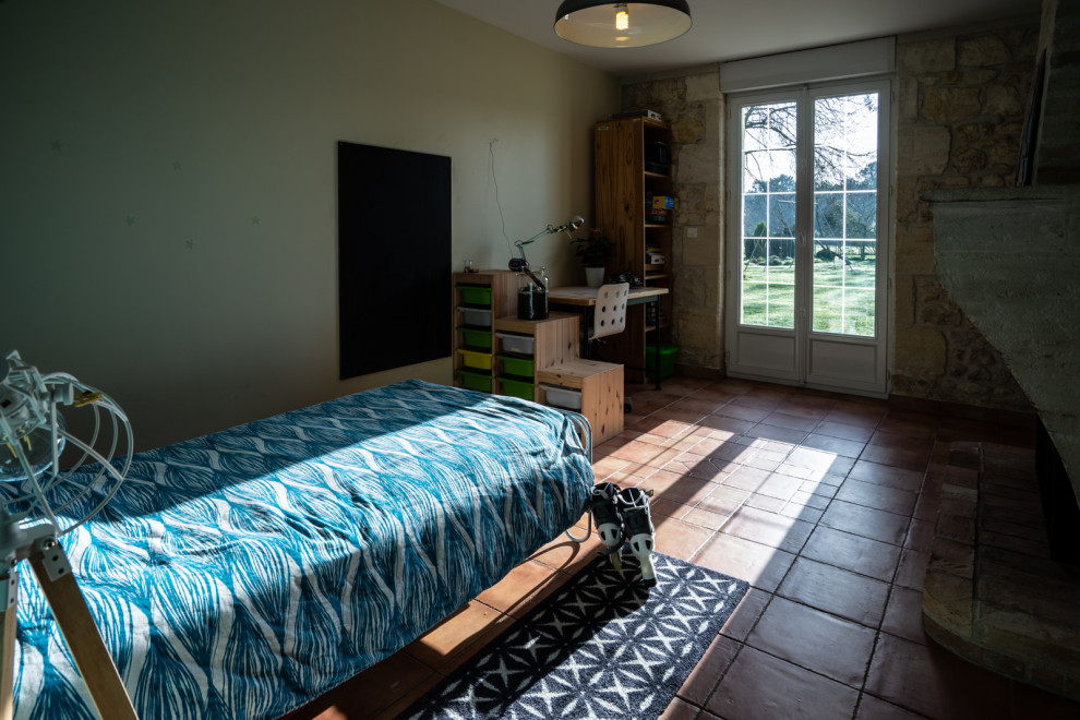 Exemple d'une grande chambre d'enfant nature avec un mur beige, tomettes au sol et un sol beige.