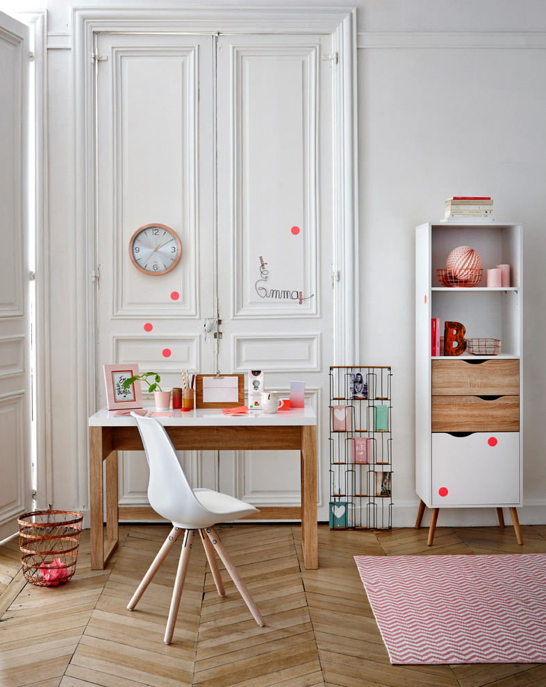 Foto på ett mellanstort nordiskt barnrum kombinerat med skrivbord, med vita väggar och mellanmörkt trägolv