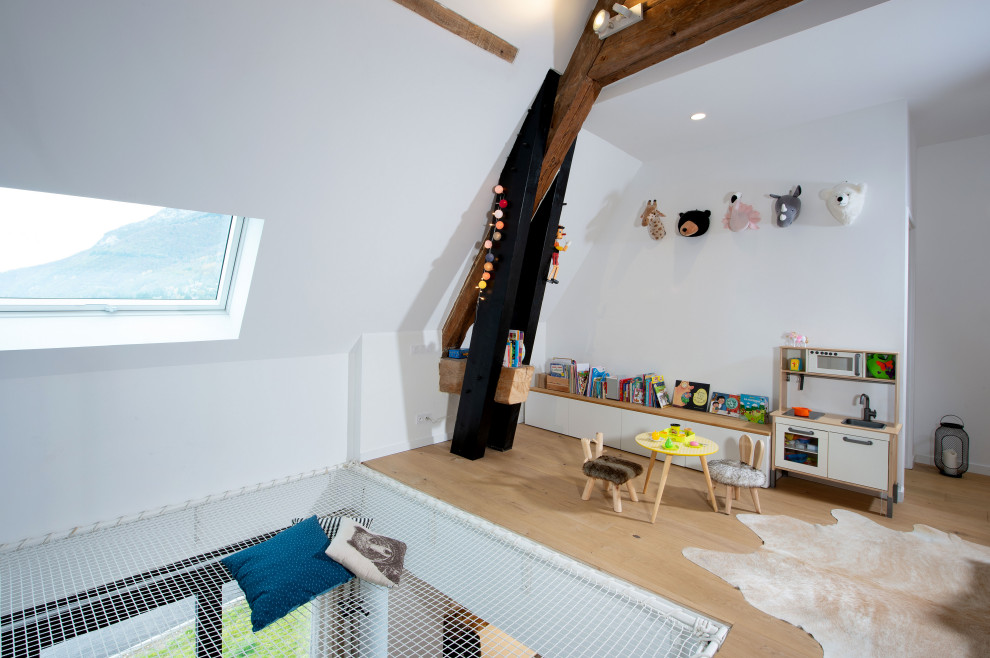 Immagine di una cameretta per bambini da 4 a 10 anni minimalista di medie dimensioni con pareti bianche, parquet chiaro e travi a vista