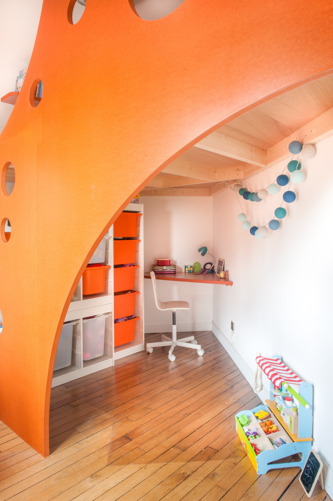 Exempel på ett mellanstort modernt könsneutralt barnrum kombinerat med skrivbord och för 4-10-åringar, med vita väggar och brunt golv
