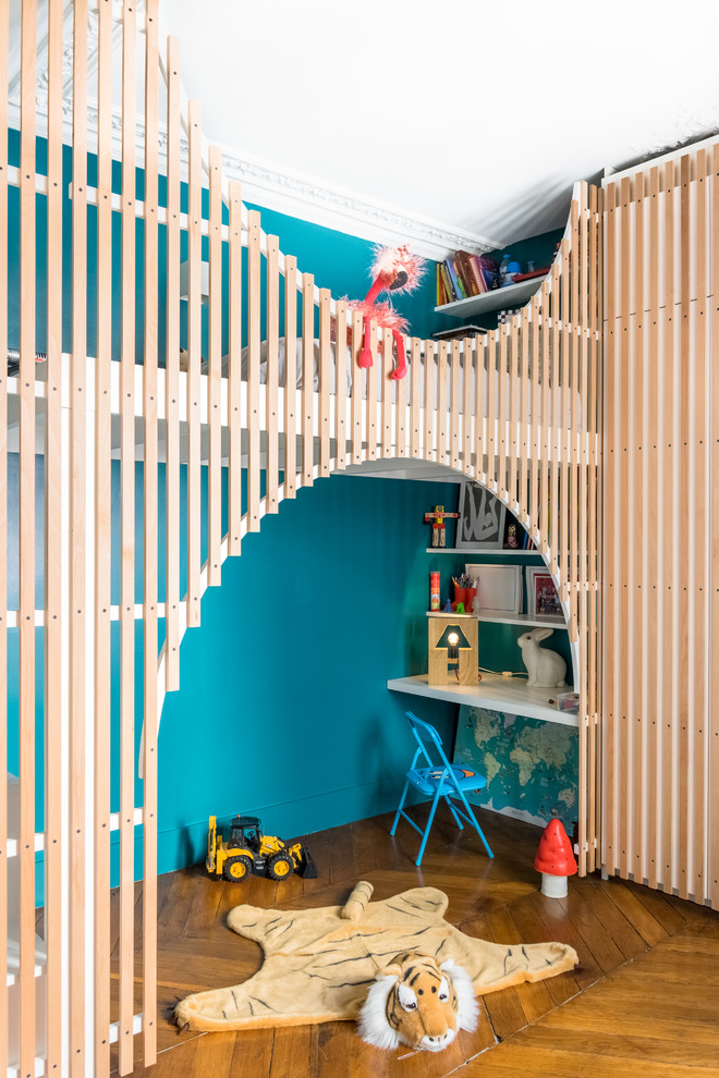 Contemporary children’s room in Paris with blue walls, medium hardwood flooring and brown floors.