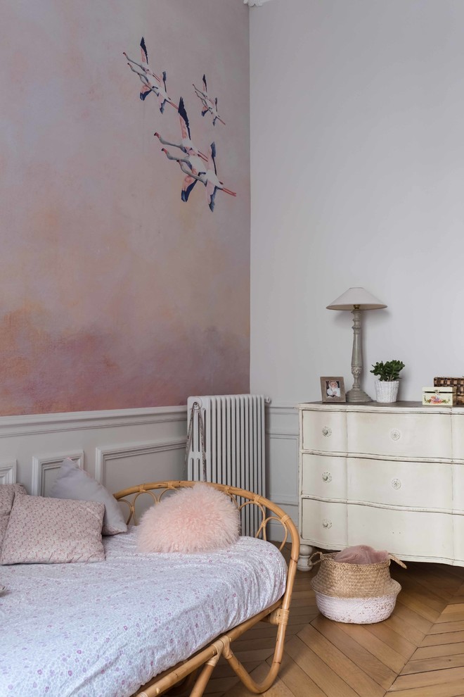 Réalisation d'une chambre d'enfant tradition avec un mur rose, parquet clair et un sol beige.
