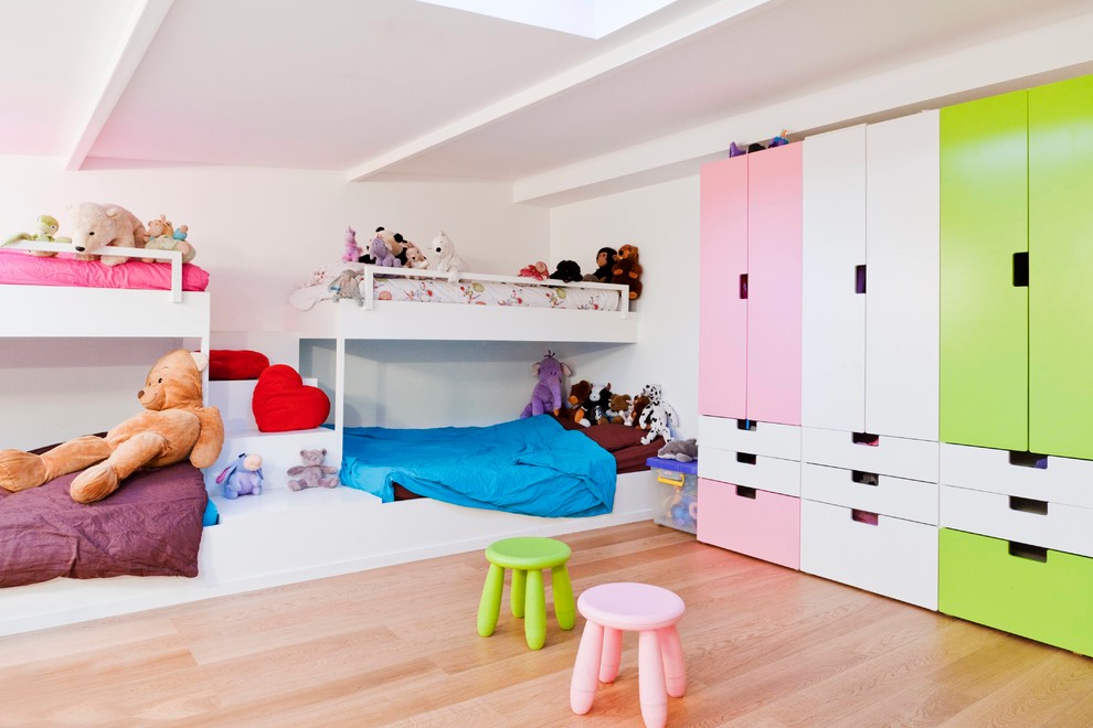 Inredning av ett modernt stort könsneutralt barnrum kombinerat med sovrum och för 4-10-åringar, med vita väggar och ljust trägolv