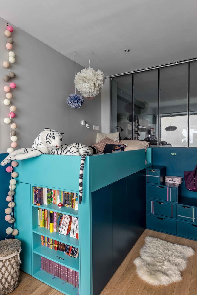 パリにある中くらいなインダストリアルスタイルのおしゃれな子供部屋 (青い壁、淡色無垢フローリング、ティーン向け) の写真