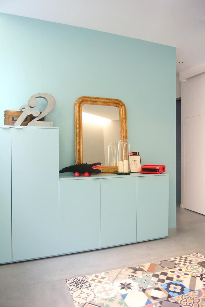 Esempio di una cameretta neutra da 4 a 10 anni contemporanea di medie dimensioni con pareti blu e pavimento in cemento
