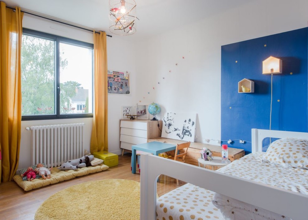 Idée de décoration pour une chambre d'enfant de 4 à 10 ans design avec un mur bleu, un sol en bois brun et un sol marron.