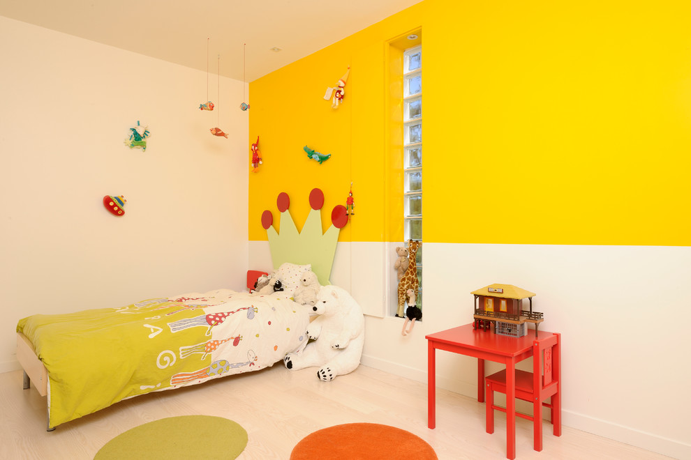 На фото: нейтральная детская в современном стиле с спальным местом, светлым паркетным полом и разноцветными стенами для ребенка от 4 до 10 лет