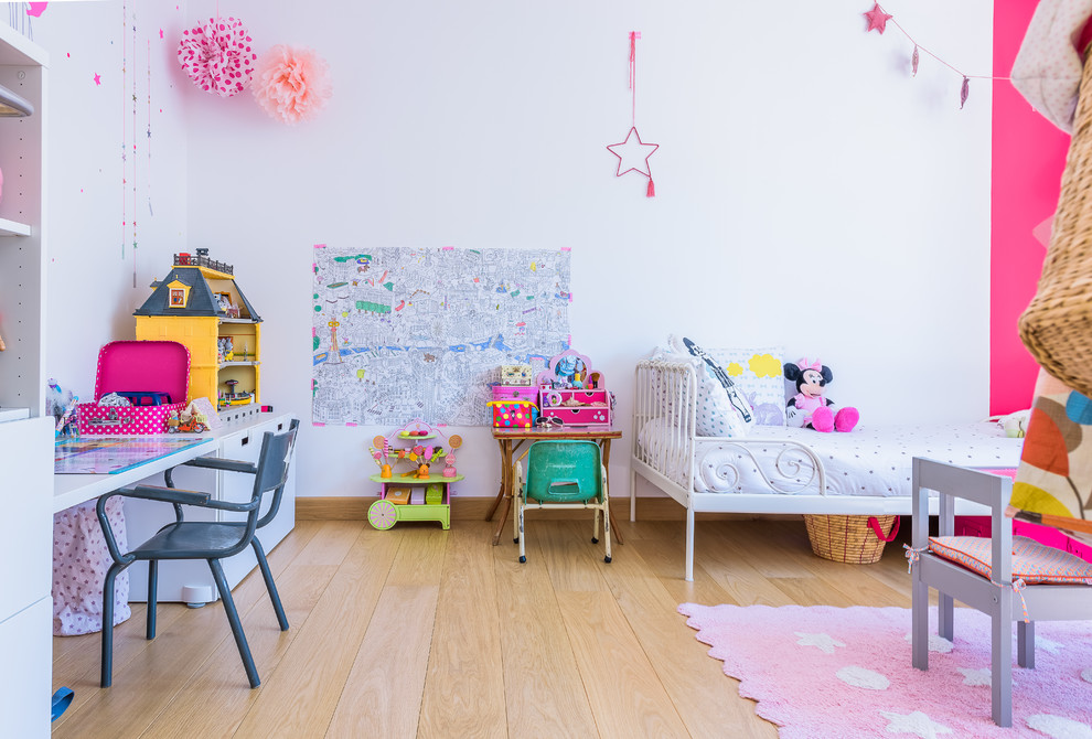 Modern inredning av ett stort flickrum kombinerat med sovrum och för 4-10-åringar, med vita väggar och ljust trägolv