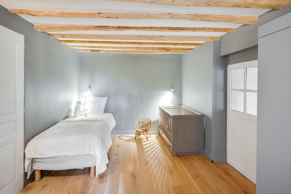 Diseño de dormitorio infantil de 1 a 3 años campestre de tamaño medio con paredes grises y suelo de madera clara