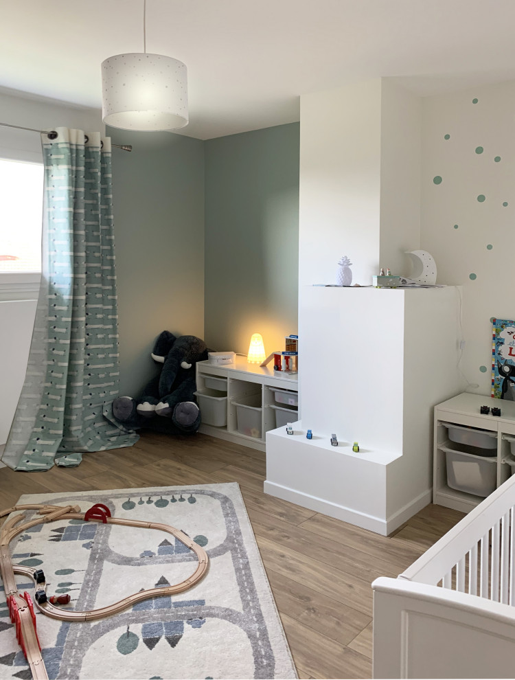 Aménagement d'une grande chambre d'enfant de 1 à 3 ans avec un mur blanc, parquet clair et un sol marron.